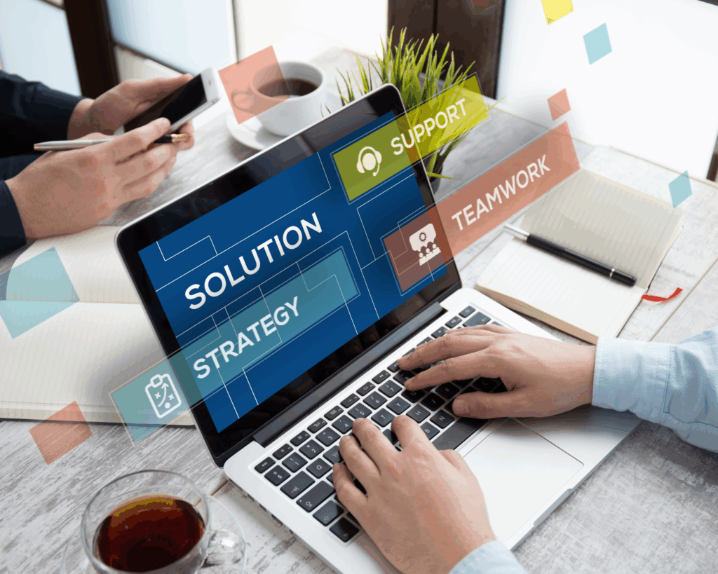 Homme avec deux mains sur le pc portable où il y a écrit solution, support, strategie, travail d'équipe