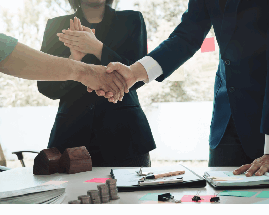 Deux hommes se serrent la main et une femme en second plan applaudit